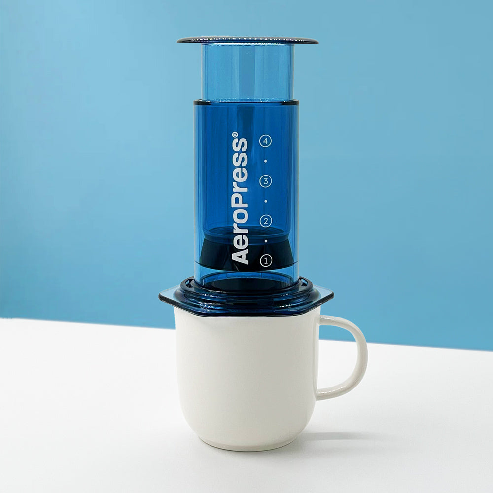 AeroPress Clear bleue, cafetière filtre manuelle compacte pour préparer un café de spécialité doux et équilibré.
