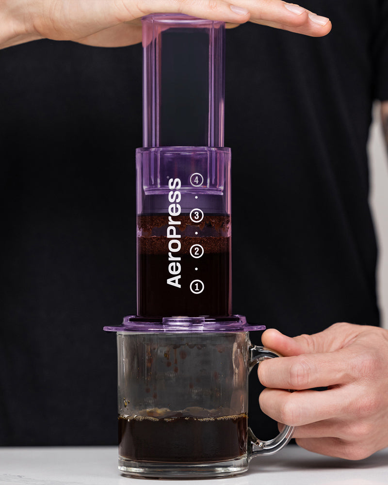 AeroPress Clear colorée utilisée pour la préparation du café de spécialité avec méthode douce et extraction maîtrisée.